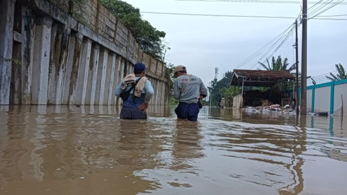 Dua orang berdiri di genangan air